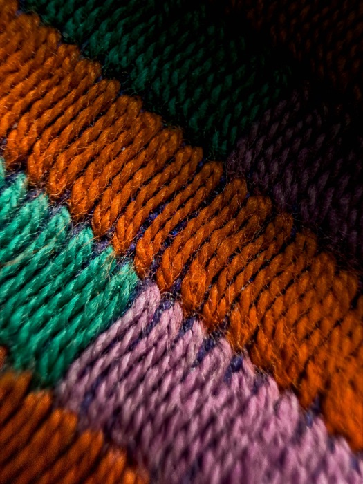 Close-up of colorful knitted fabric with diagonal stripes, representing Playscape's playful texture