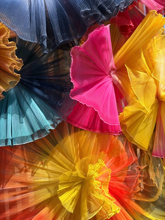 Abstract display of colorful pleated fabric ruffles, representing Playscape's layered volume